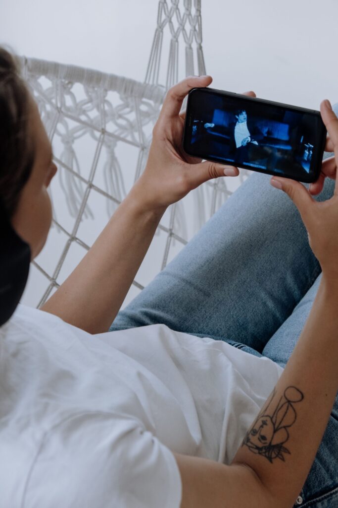 A person watching a video on their phone illustrates Catch-Up TV's data consumption based on picture quality.
